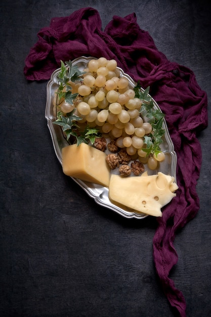 Uva e formaggio bianchi freschi dolci su un piatto d'annata.