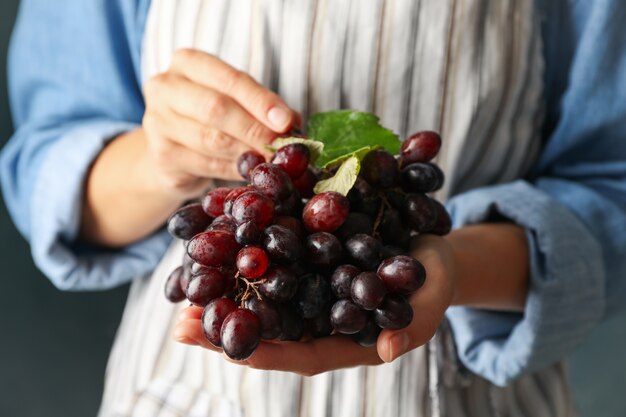 Uva matura fresca della stretta della donna, vista frontale