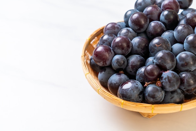 uva nera fresca sul tavolo bianco