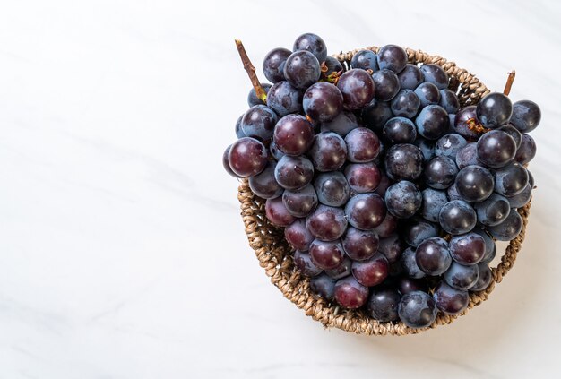 uva nera fresca sul tavolo bianco