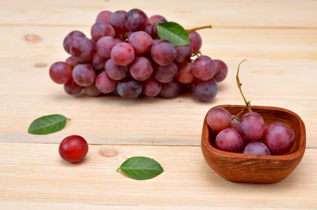 Uva rossa in una ciotola di legno sul tavolo