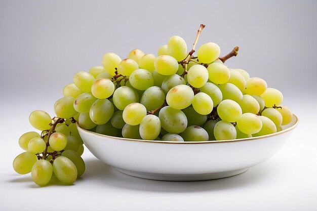 Uva verde in un piatto su uno sfondo bianco