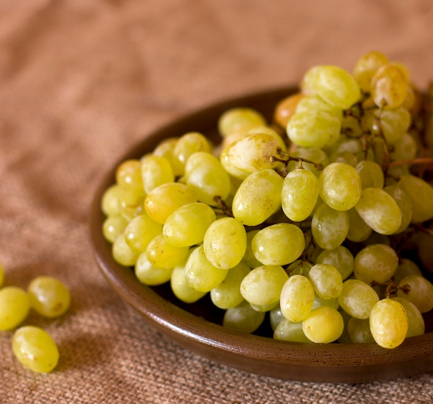 Uva verde su un piatto di argilla marrone