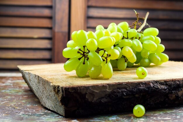 Uva verde succosa su una tavola di legno rustica