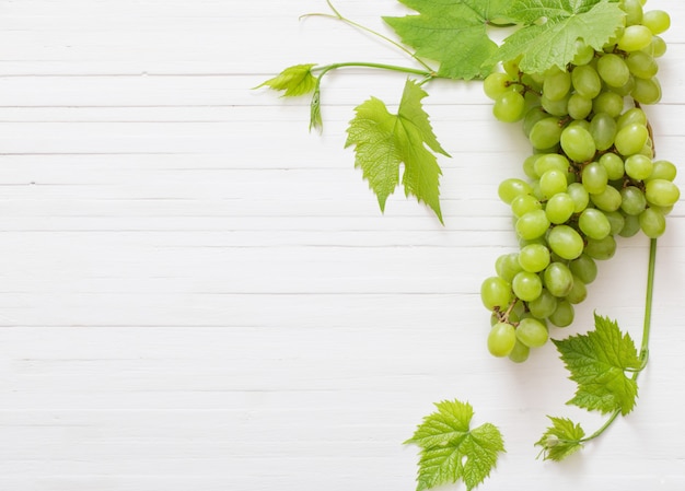 Uva verde sulla tavola di legno bianca