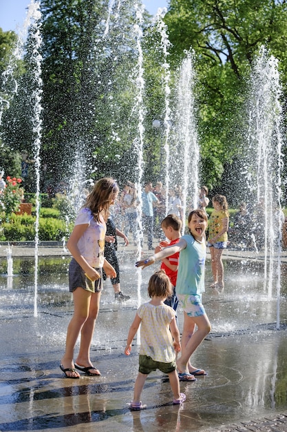 UZHGOROD, UCRAINA - 28 maggio 2017: Bambini felici che giocano in una fontana d'acqua in una giornata calda