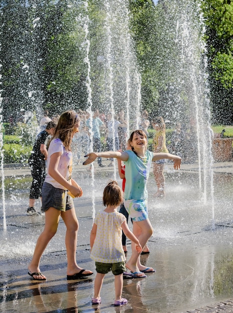 UZHGOROD, UCRAINA - 28 maggio 2017: Bambini felici che giocano in una fontana d'acqua in una giornata calda