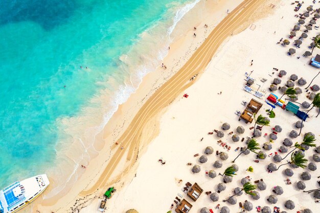 Vacanza al mare e sfondo di viaggio. Vista aerea del drone della bellissima spiaggia tropicale atlantica con ombrelloni di paglia e palme. Spiaggia di Bavaro, Punta Cana, Repubblica Dominicana.