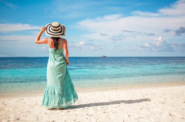 Vacanza al mare. Ragazza che cammina lungo una spiaggia tropicale alle Maldive.