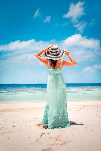 Vacanza al mare. Ragazza che cammina lungo una spiaggia tropicale alle Maldive.