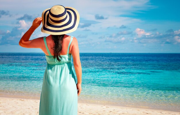 Vacanza al mare. Ragazza che cammina lungo una spiaggia tropicale delle Maldive.