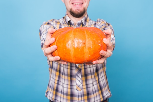 Vacanza halloween e concetto di persone ravvicinata di una grande zucca arancione nelle mani di un uomo su a