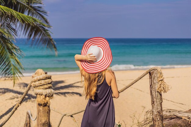 Vacanza sull'isola tropicale Donna con cappello che gode della vista sul mare dal ponte di legno