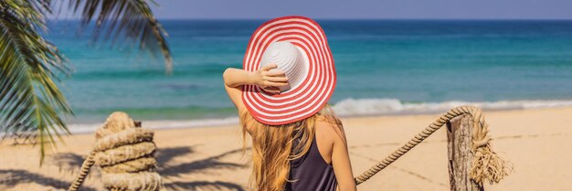 Vacanza sull'isola tropicale donna in cappello che gode della vista sul mare dal formato lungo dell'insegna del ponte di legno