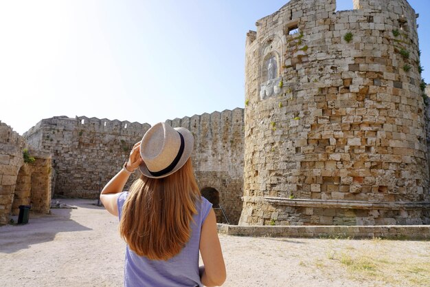 Vacanze a Rodi in Grecia Vista posteriore della ragazza del viaggiatore che visita le fortificazioni di Rodi Giovane turista femminile che visita l'Europa meridionale