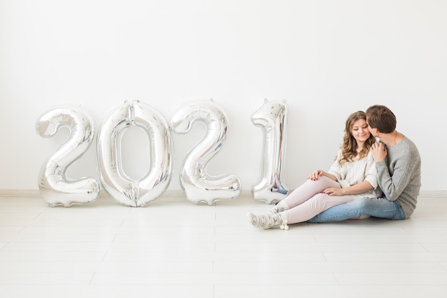 Vacanze, concetto di festa e festa - Felice coppia di innamorati tiene palloncini argento 2021