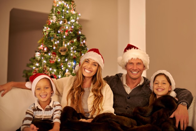 Vacanze di Natale e ritratto di famiglia con amore e felici insieme per festeggiare a casa genitori con bambini e sorriso Madre padre e bambini con famiglia felice e decorazione dell'albero di Natale