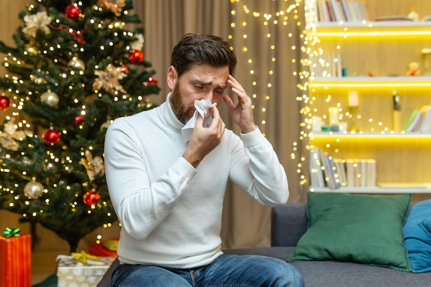 Vacanze di Natale rovinate un giovane bell'uomo si è ammalato alla vigilia di capodanno si siede a casa sul divano