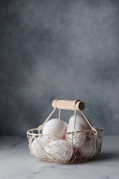 Vacanze di Pasqua di primavera uova bianche in un tavolo grigio cestino