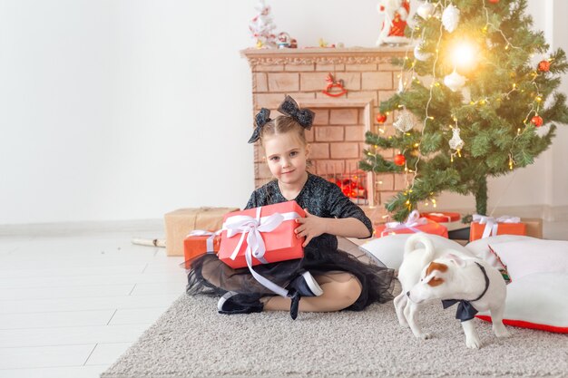 Vacanze e concetto di infanzia - Ritratto di una bambina felice e carina con un regalo di Natale