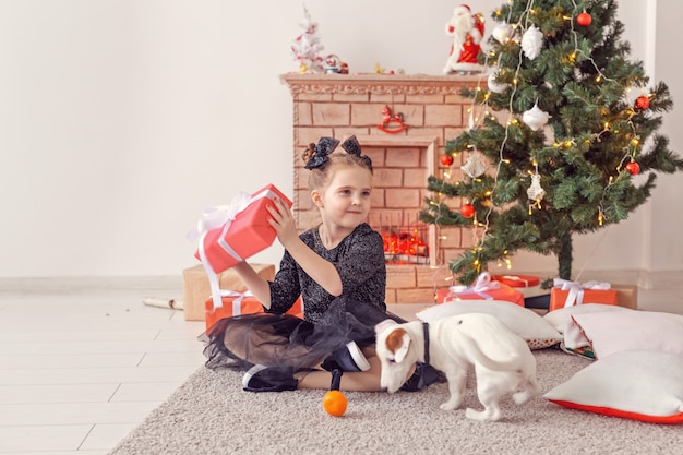 Vacanze e concetto di infanzia - Ritratto di una bambina felice e carina con un regalo di Natale