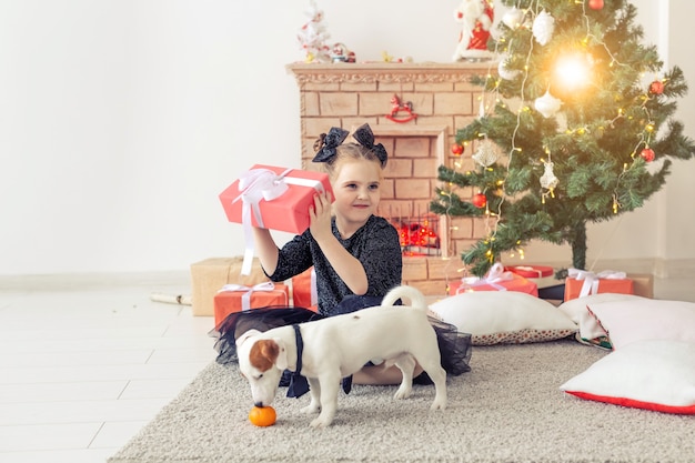 Vacanze e concetto di infanzia - Ritratto di una bambina felice e carina con un regalo di Natale