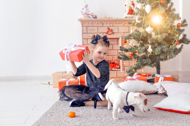 Vacanze e concetto di infanzia - Ritratto di una bambina felice e carina con un regalo di Natale