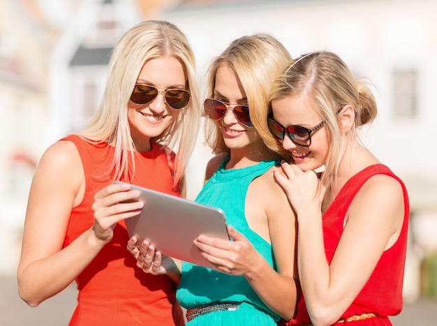 vacanze e concetto di turismo - belle ragazze bionde toursits che esaminano tablet pc in città