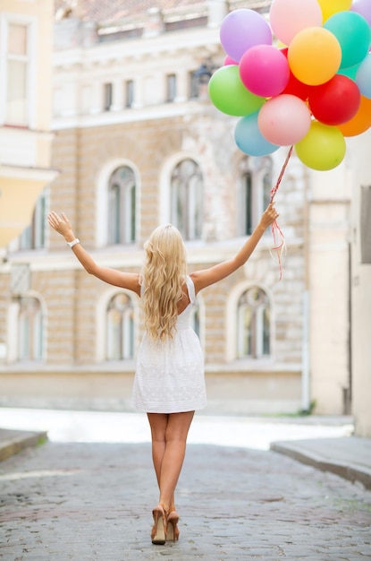 vacanze estive, celebrazione e concetto di stile di vita - bella donna con palloncini colorati in città