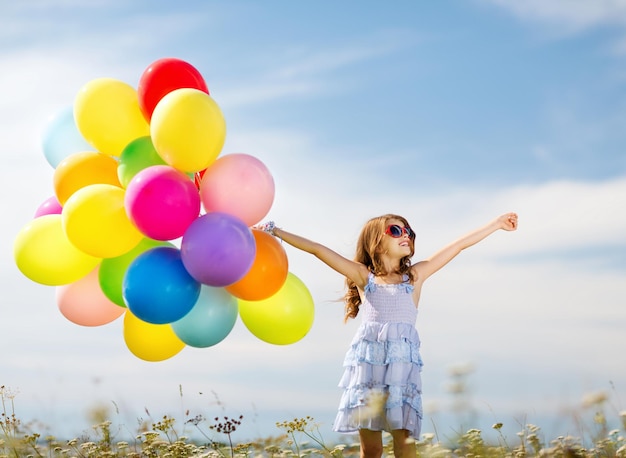 vacanze estive, celebrazione, famiglia, bambini e concetto di persone - ragazza felice con palloncini colorati