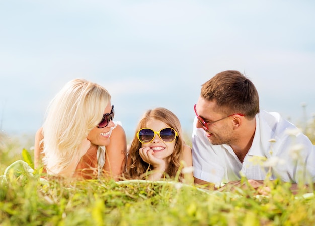 vacanze estive, concetto di bambini e persone - famiglia felice con cielo blu ed erba verde