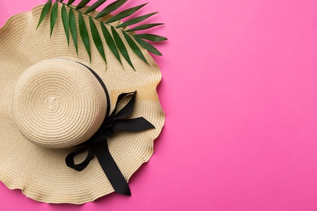 Vacanze estive Concetto estivo con cappello di paglia e foglia tropicale Spazio per la copia vista dall'alto piatto