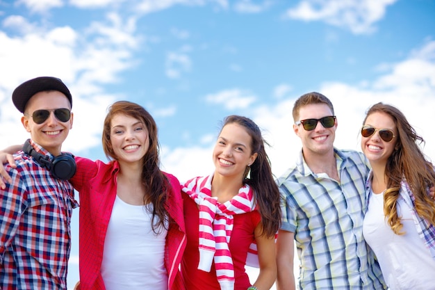 vacanze estive e concetto adolescenziale - gruppo di adolescenti sorridenti appesi all'esterno