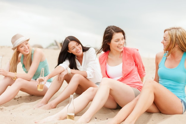 vacanze estive e concetto di vacanza - ragazze sorridenti con drink sulla spiaggia