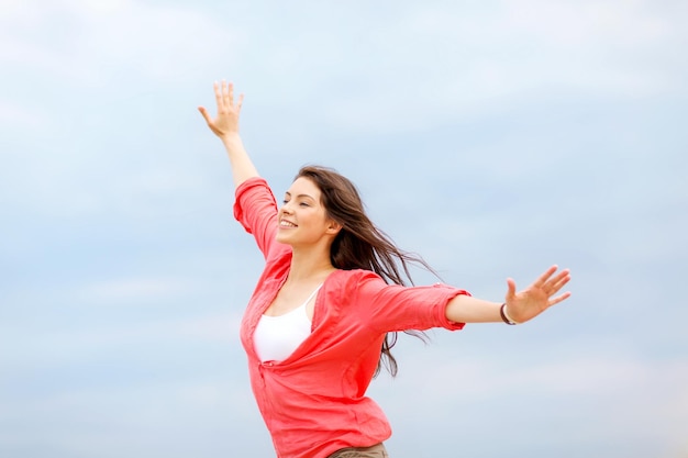 vacanze estive e vacanze - ragazza con le mani in alto sulla spiaggia