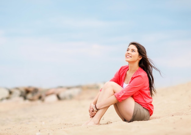 vacanze estive e vacanze - ragazza seduta sulla spiaggia
