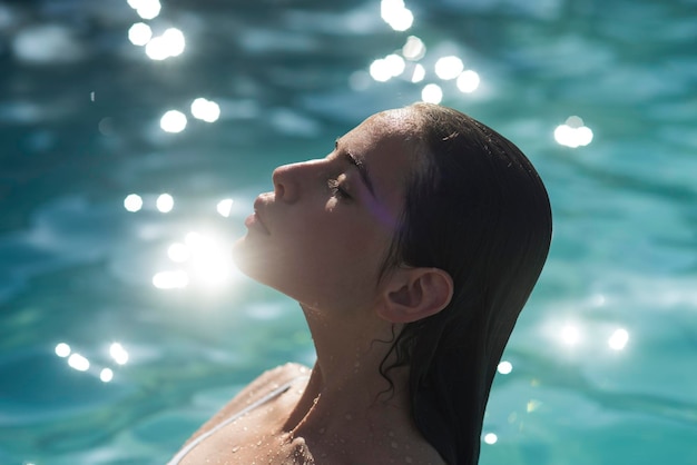 Vacanze estive e viaggi nell'oceano Vacanze estive di una bella giovane donna in piscina o sull'oceano