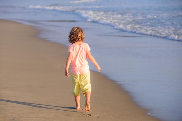 Vacanze estive in spiaggia bambino che gioca nell'oceano vacanze estive per bambini al mare