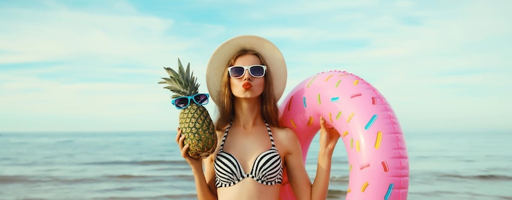 Foto vacanze estive turismo felice giovane donna con nuotare ananas anello gonfiabile sulla spiaggia