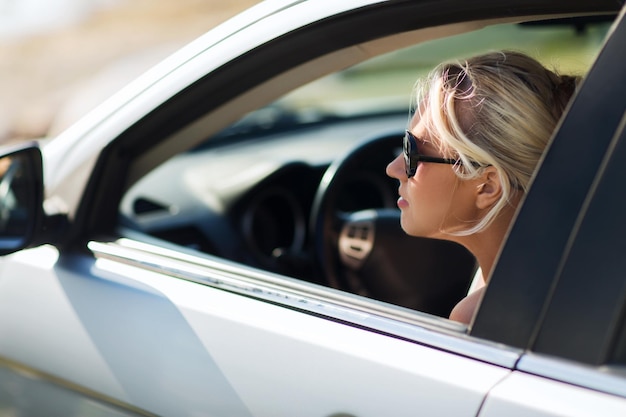 vacanze estive, vacanze, viaggi, viaggio su strada e concetto di persone - adolescente sorridente felice o giovane donna in auto