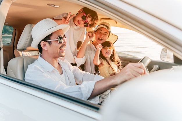 Vacanze in famiglia asiatiche Genitori di famiglia felici che tengono in braccio i bambini che volano nel cielo