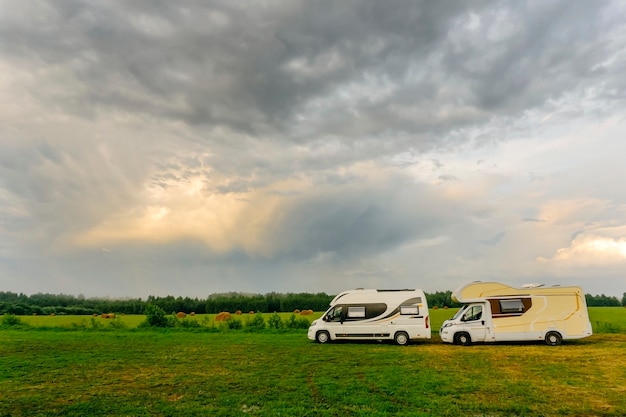 Vacanze in famiglia e viaggi (viaggio) all'aperto in camper (auto per roulotte). Due camper in un campeggio estivo all'aperto. Viaggia (viaggio) in auto concetto.