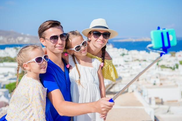 Vacanze in famiglia in Europa. Genitori e bambini che prendono la foto del selfie nella città di Mykonos in Grecia