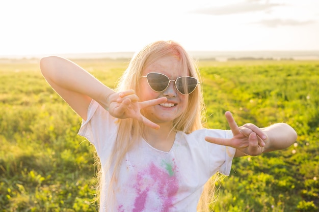 Vacanze indiane, divertimento e concetto di infanzia - ragazza con gli occhiali sorridente, divertendosi sull'holi