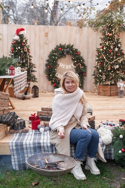 Vacanze invernali e celebrazioni Giovane donna vicino all'albero di Natale all'aperto