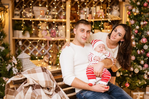 Vacanze invernali e concetto di persone felice giovane famiglia papà mamma e figlio piccolo tra le braccia di padre cele...