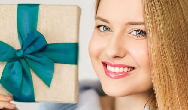 Vacanze invernali presenti e concetto di Buon Natale donna felice sorridente e in possesso di confezione regalo avvolta