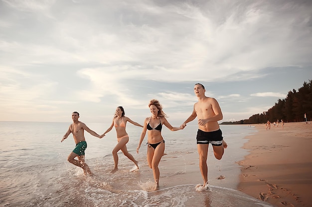 vacanze, le persone corrono in spiaggia / vacanze estive, vacanze al mare, le persone felici riposano