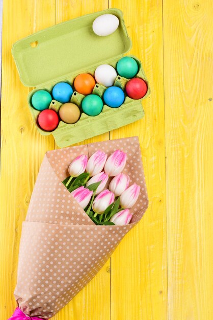 Vacanze primaverili Preparazione celebrazione delle vacanze uova dipinte nel vassoio delle uova Bouquet di fiori di tulipano Vacanze sane e felici Buona Pasqua Caccia alle uova Decorazioni pasquali