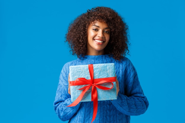 Vacanze, stagione invernale e concetto di natale. Bella donna afro-americana carina